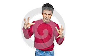 Young handsome man wearing casual clothes shouting frustrated with rage, hands trying to strangle, yelling mad