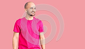 Young handsome man wearing casual t shirt looking away to side with smile on face, natural expression