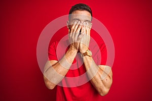 Young handsome man wearing casual t-shirt over red  background rubbing eyes for fatigue and headache, sleepy and tired