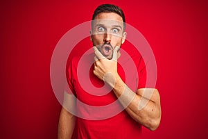 Young handsome man wearing casual t-shirt over red isolated background Looking fascinated with disbelief, surprise and amazed