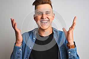 Young handsome man wearing denim shirt standing over isolated white background very happy and excited, winner expression