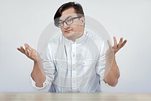 Young handsome man wearing doctor or scientis white coat with disbelief gesture hands up and excited perplexity face expression.