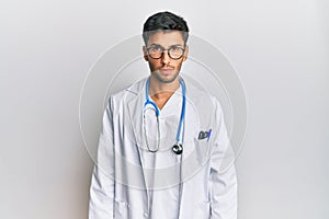 Young handsome man wearing doctor uniform and stethoscope skeptic and nervous, frowning upset because of problem