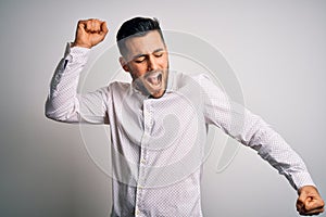 Young handsome man wearing elegant shirt standing over isolated white background Dancing happy and cheerful, smiling moving casual