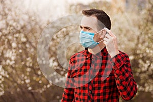 Joven lindo hombre agotador contaminación sobre el proteger externo 