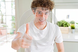Young handsome man wearing glasses doing happy thumbs up gesture with hand