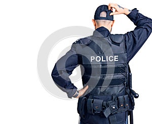 Young handsome man wearing police uniform backwards thinking about doubt with hand on head