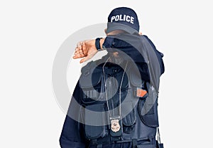 Young handsome man wearing police uniform covering eyes with arm, looking serious and sad
