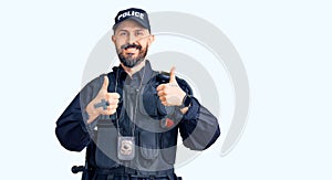 Young handsome man wearing police uniform success sign doing positive gesture with hand, thumbs up smiling and happy