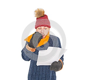 Young handsome man wearing in red hat and blue pullover feeling cold hold high electricity gas bill on white background