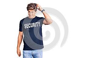 Young handsome man wearing security t shirt confuse and wondering about question