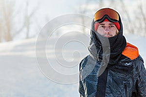 Young handsome man wearing ski mask and sport jacket loking at the camera