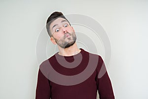 Young handsome man wearing a sweater over isolated background making fish face with lips, crazy and comical gesture