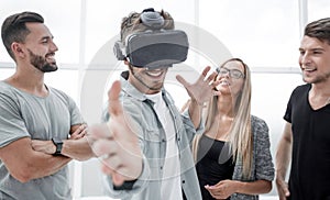 Young handsome man wearing virtual reality goggles touching cont