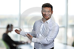 Young handsome man wearing white shirt pointing aside with hands open palms showing copy space.