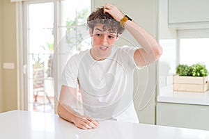 Young handsome man wearing white t-shirt at home confuse and wonder about question