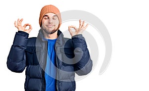Young handsome man wearing winter clothes relax and smiling with eyes closed doing meditation gesture with fingers