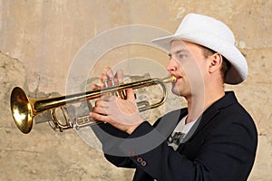 Young handsome man in white hat and jacket plays