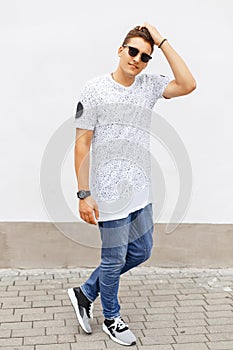 Young handsome man in a white T-shirt, blue jeans