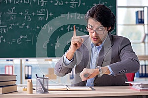 The young handsome math teacher in classroom