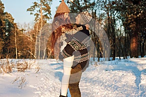 A young handsome man of European appearance and a young Asian girl in a park on the nature in winter