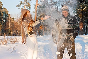 A young handsome man of European appearance and a young Asian girl in a park on the nature in winter