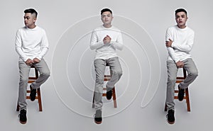 Young handsome men wearing white long sleeve t-shirt was sitting and posing in a chair with plain background