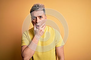 Young handsome modern man wearing yellow shirt over yellow isolated background Looking fascinated with disbelief, surprise and