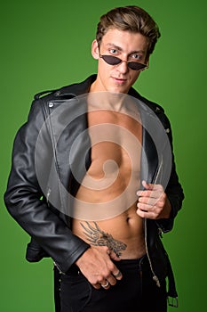 Young handsome rebellious man wearing leather jacket