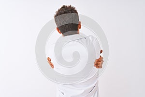 Young handsome sciencist man wearing glasses and coat over isolated white background Hugging oneself happy and positive from