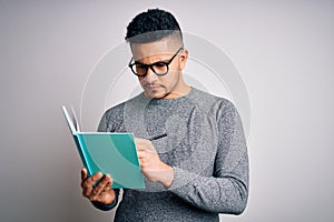 Young handsome smart student man reading book over isolated white background with a confident expression on smart face thinking