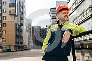 Young handsome smiling architect holding construction supervision drawings