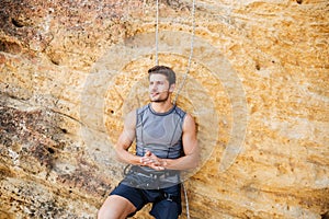 Young handsome sportsman getting ready to climb a cliff