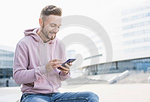 Young handsome student man using smartphone. Cheerful men holding mobile phone, technology, people concept