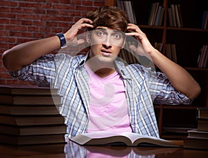 Young handsome student preparing for exams at night