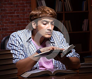 Young handsome student preparing for exams at night