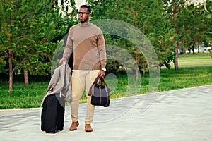 Young and handsome stylish model afro- american man in a stylish suit in a summer park latino hispanic businessman black