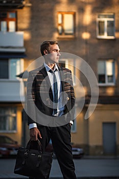 Young handsome successful stylish businessman standing