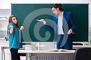 The young handsome teacher and female student in the classroom