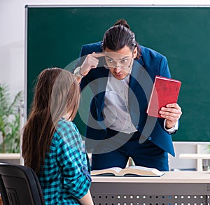 Young handsome teacher and female student in the classroom