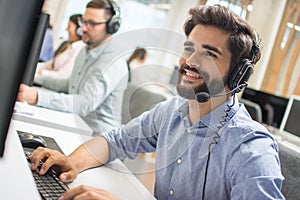 Young handsome technical support dispatcher working in call center