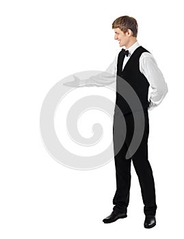 Young handsome waiter doing a welcome gesture