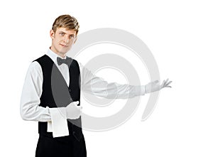 Young handsome waiter gesturing welcome
