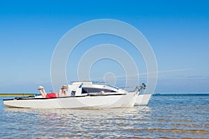 Young and handsome woman with laptop computer on sailboat. Freelance work concept