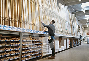 Young handyman selecting a length of cut timber