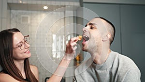 Young happy active family couple dancing laughing together preparing food at home, carefree joyful husband and wife