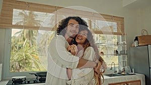 Young happy active married couple dancing laughing together cooking meals at home, carefree joyful husband and wife have