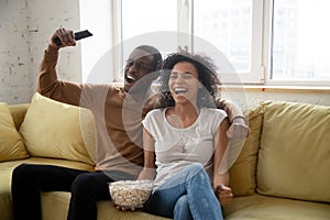 Young happy african american couple watching funny movie.