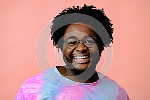 young happy african american man posing in the studio over pink background