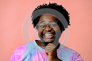 young happy african american man posing in the studio over pink background